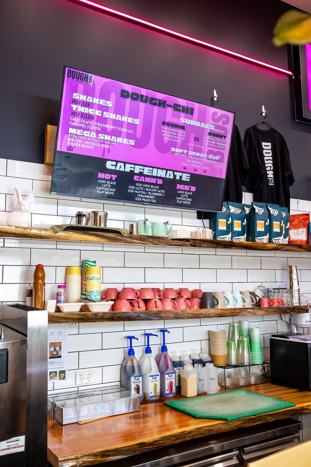 Dough Bros shop — neon-pink Dough-Chi menu, subway tile and the make line